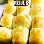 A baking tray filled with golden, fluffy Texas Roadhouse rolls sits on a white surface, with a yellow kitchen towel in the background. Text on the image reads "Texas Roadhouse Rolls.
