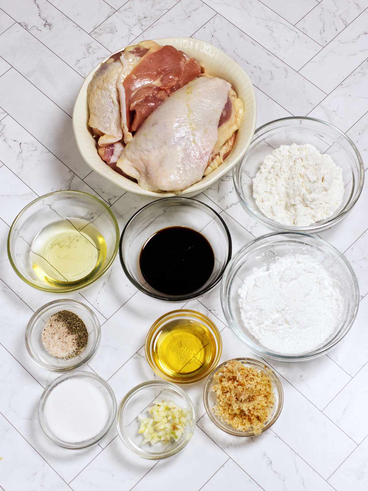 Ingredients for chicken karaage including chicken, soy sauce, garlic, ginger, cornstarch, flour, and seasonings.