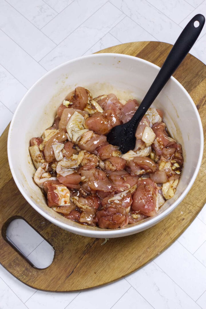 Chicken pieces coated in karaage marinade in a white bowl.
