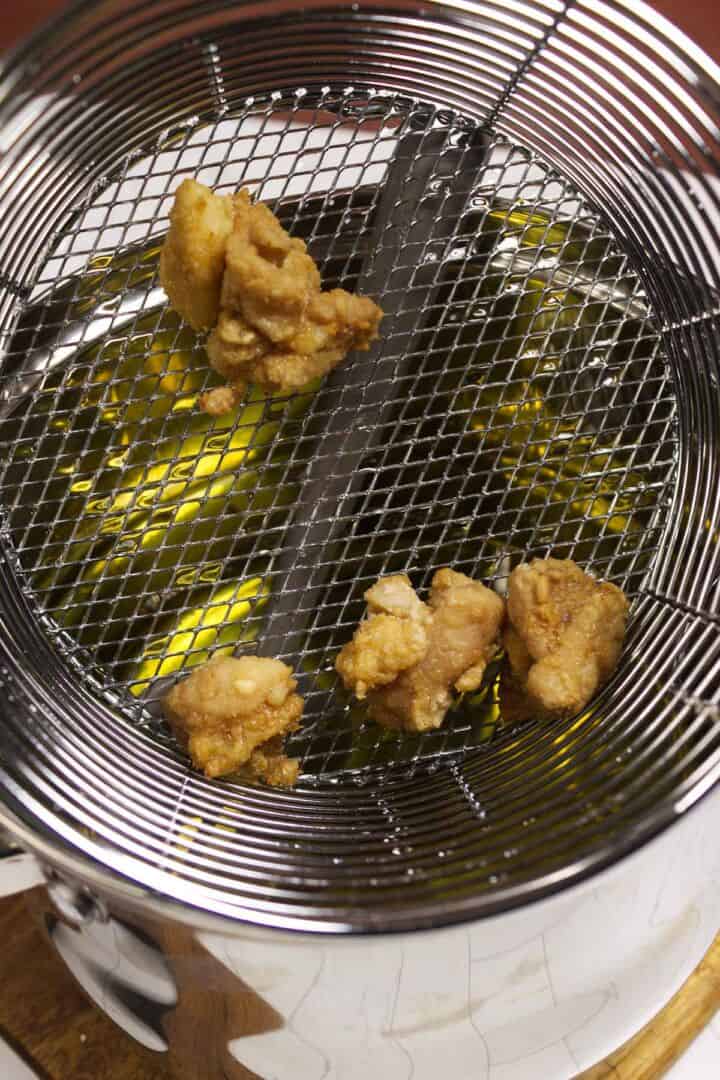 Chicken karaage frying a second time to crisp the coating.