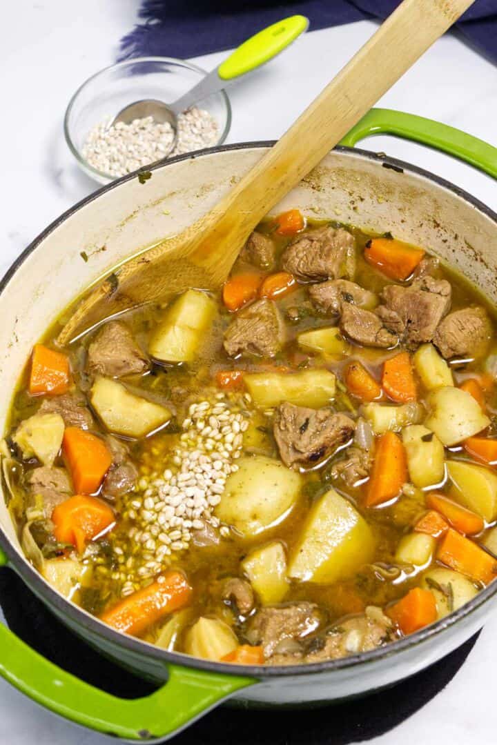 Adding barley to Irish lamb stew.