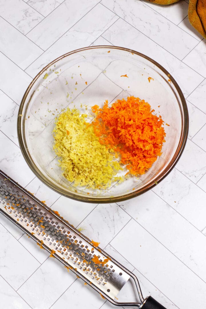 Grated carrot and frozen ginger in a glass bowl for Japanese steakhouse ginger dressing.