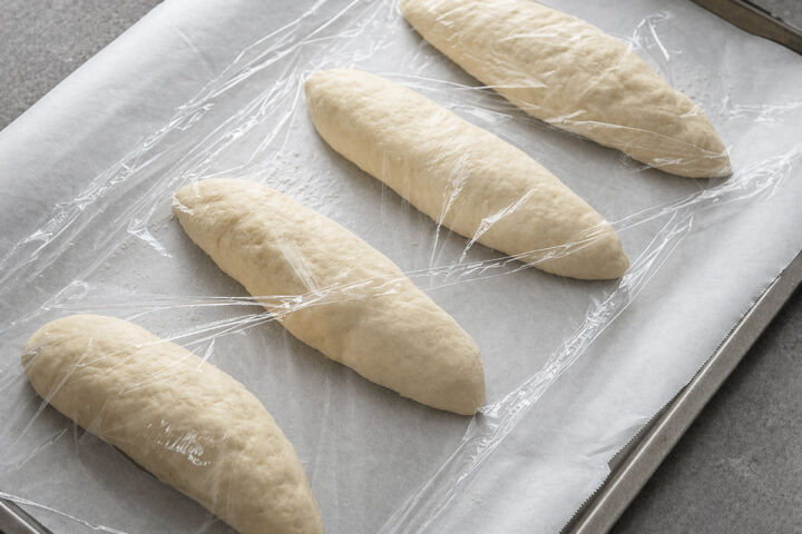 Shaped bolillo rolls on baking sheet before proofing.