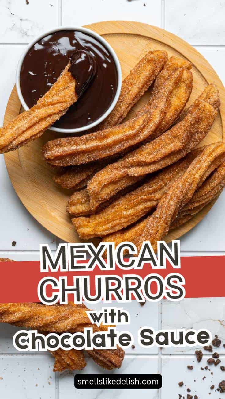 A wooden plate of sugar-coated Mexican churros is served with a bowl of rich chocolate sauce for dipping. Crumbs are scattered on a white surface, and bold text on the image reads "Mexican Churros with Chocolate Sauce.