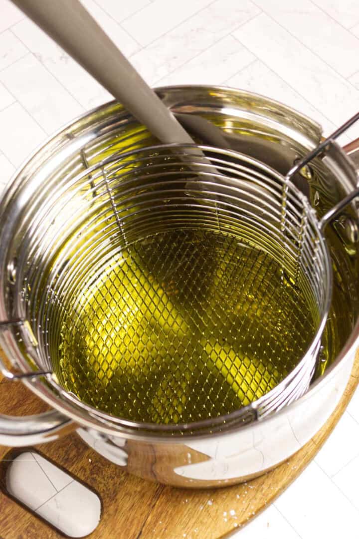 Heating oil in a deep pot to 350°F for frying churros.