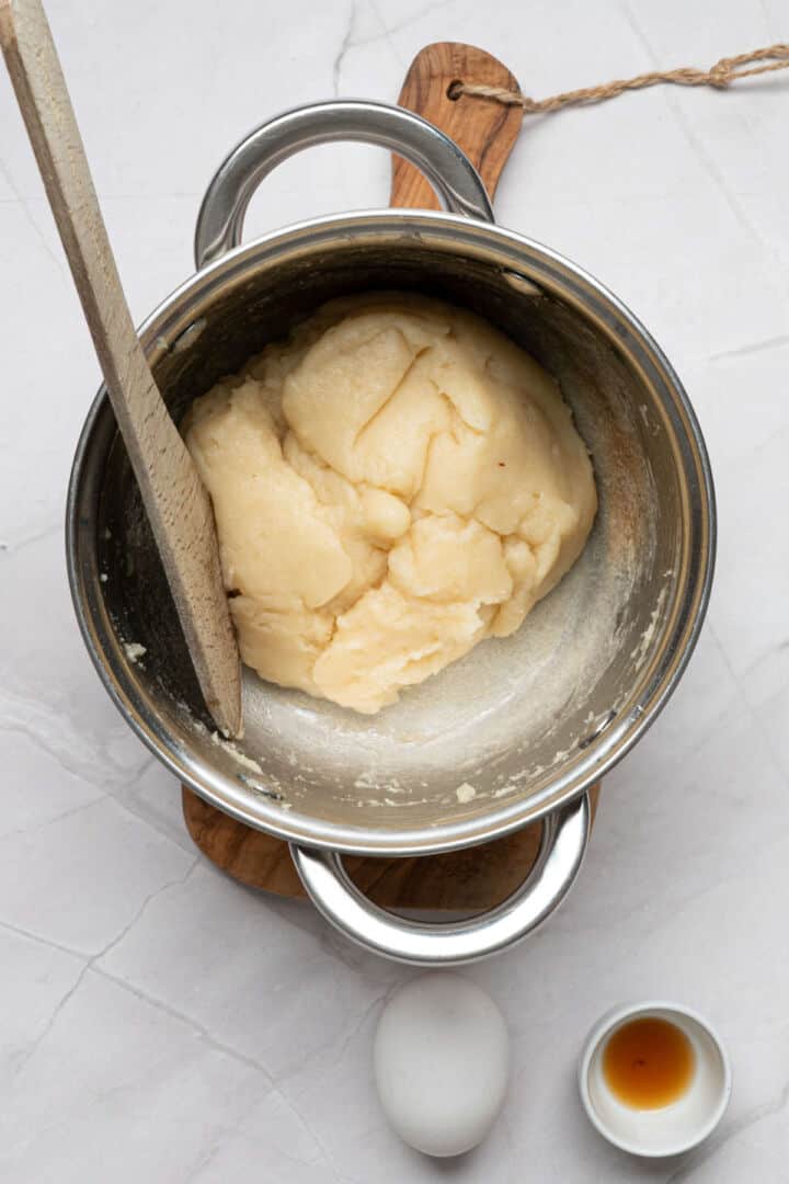 Stirring churro dough in saucepan until it forms a smooth ball.