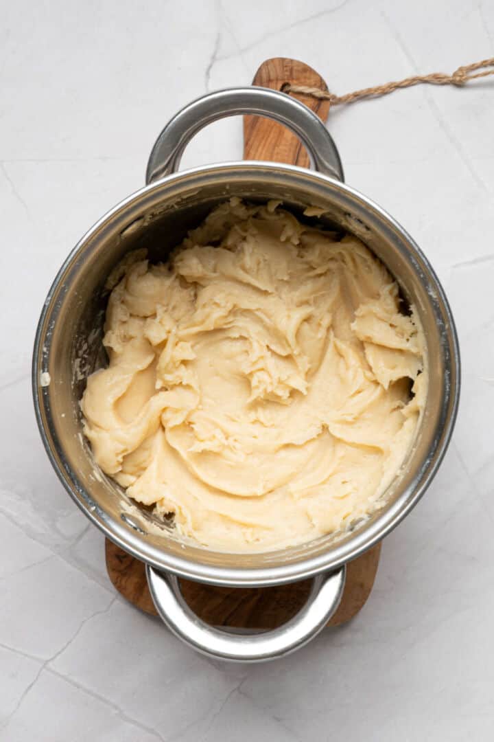 Smooth churro dough resting in saucepan after mixing and before adding to pastry bag.