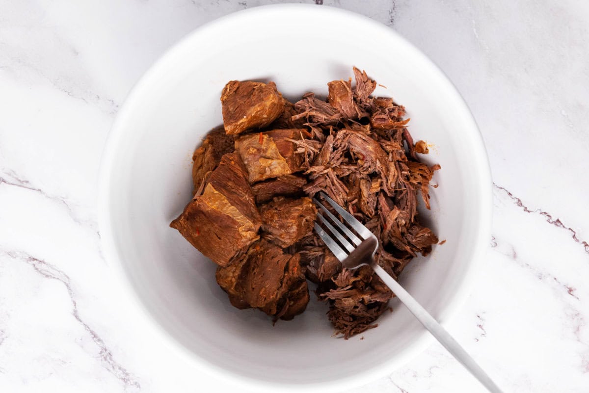 Tender shredded beef from birria in a bowl.