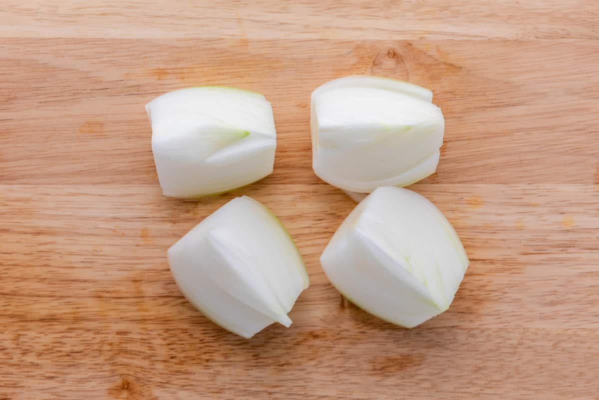 Chopped white onion pieces on a cutting board.