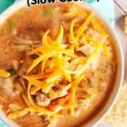 Southwest chicken tortilla soup with shredded cheese and tortilla strips in a bowl.