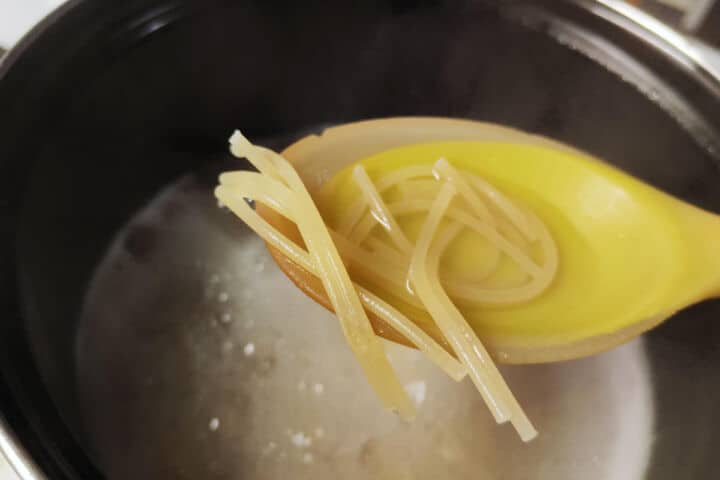 Short Mexican fideo noodles cooking in boiling water for chicken fideo soup.