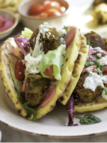 Crispy falafel wraps with tzatziki, lettuce, tomatoes, pickled onions, radishes, and feta.
