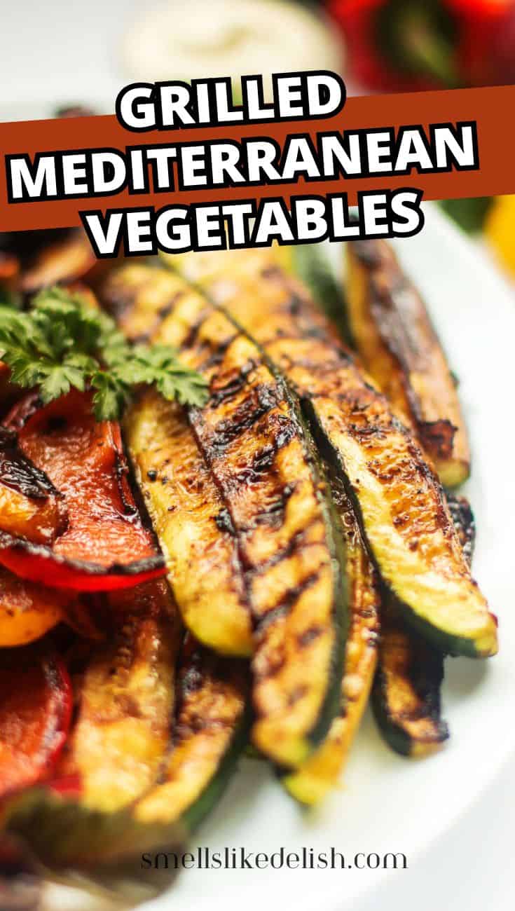 Close-up of grilled zucchini, bell peppers, red onion, and eggplant with herbs.