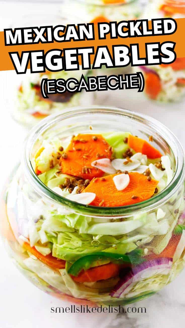 Jars of escabeche with sliced carrots, jalapenos, cabbage, and red onions in a tangy vinegar brine.