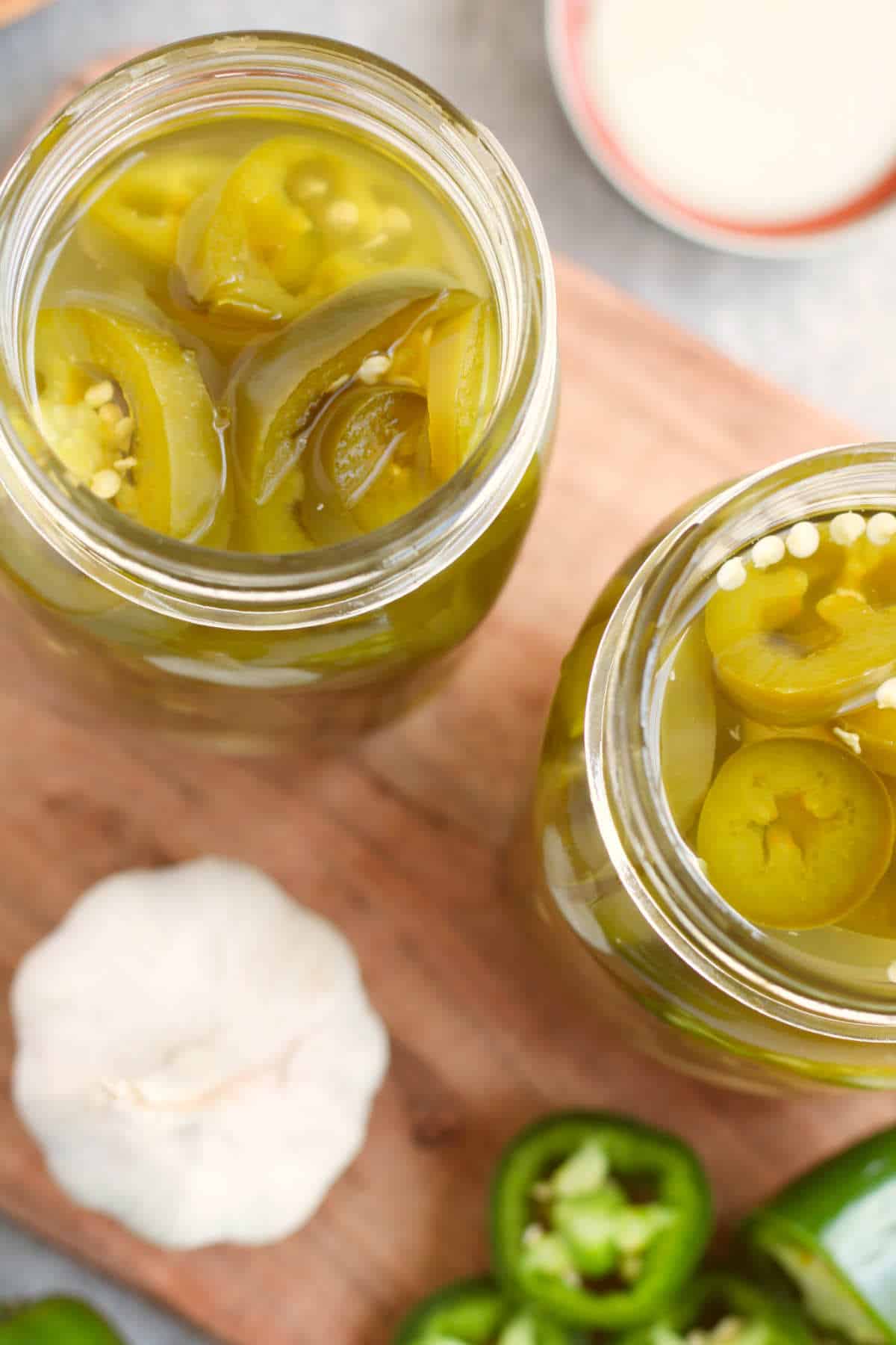 Overhead view of mason jars filled with pickled jalapenos and brine.