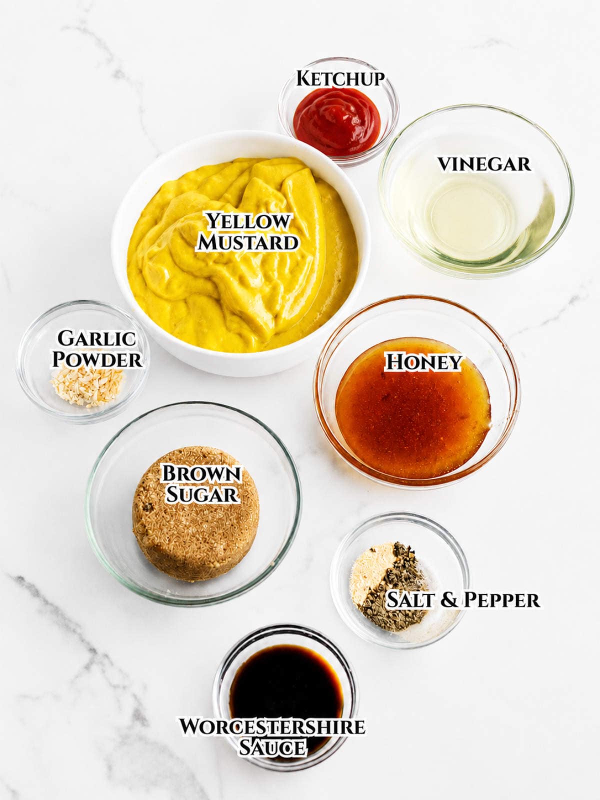 Eight labeled bowls with Carolina Gold BBQ sauce ingredients arranged in a circle on a white marble surface.
