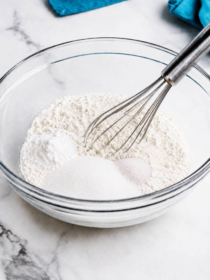 1:1 gluten free flour blend, sugar, cornstarch, baking powder, and salt in a glass bowl with a whisk.