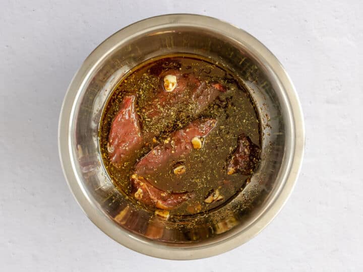Top sirloin steaks coated in balsamic marinade with garlic and herbs.