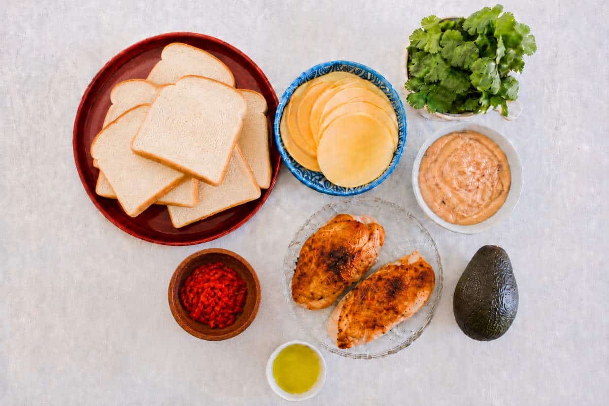 Ingredients for Panera Chipotle Chicken Avocado Melt with bread, Gouda cheese, chicken, avocado, cilantro, chipotle mayo, and sweet red peppers.