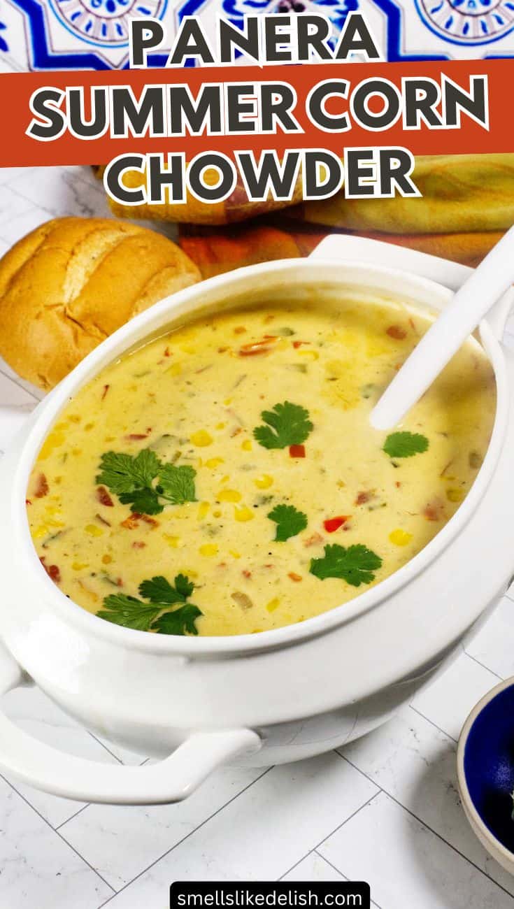 White bowl of creamy Panera Summer Corn Chowder with cilantro and a bread roll.