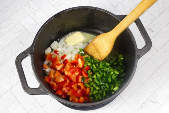 Onion, poblano, red bell pepper, and garlic sautéing in butter for Panera Summer Corn Chowder.