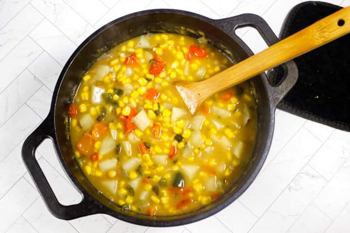 Corn and potatoes simmering in a creamy chowder base until tender.