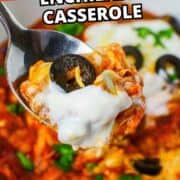 Close-up of a spoonful of slow cooker chicken enchilada casserole with sour cream, cheese, and olive; dish in background.