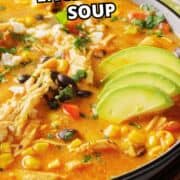 Bowl of creamy chicken enchilada soup with avocado, cilantro, corn, black beans, and chicken.