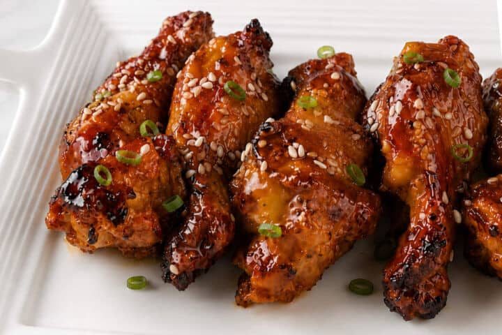Soy garlic chicken wings served with sesame seeds and sliced green onions.