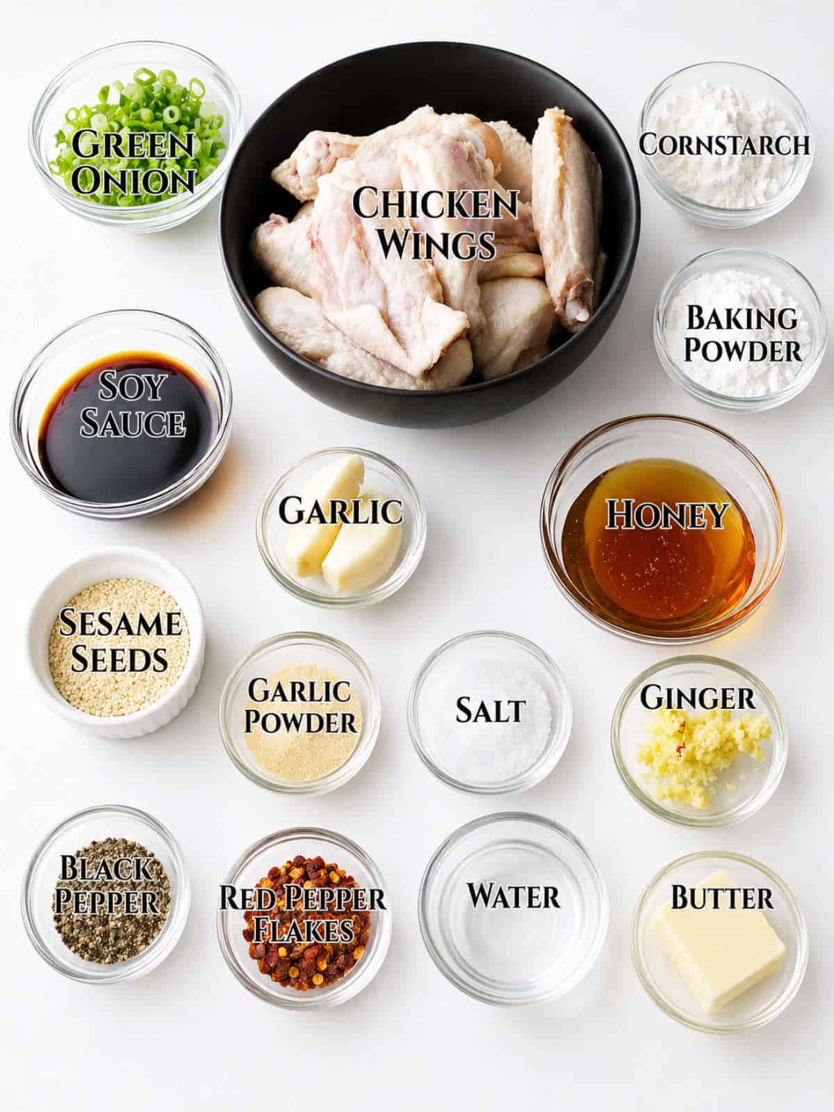 Ingredients for soy garlic chicken wings arranged in small bowls on a light surface.