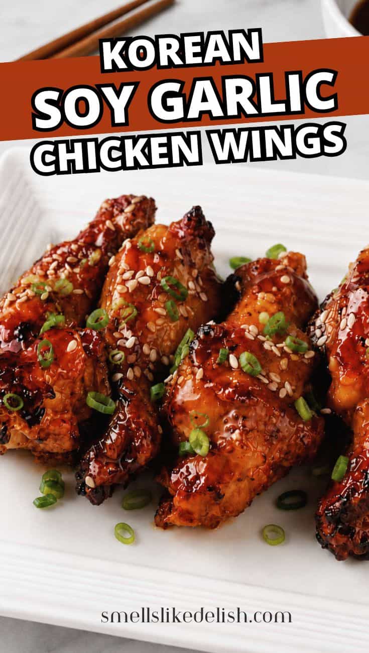 Soy garlic chicken wings with sesame seeds and green onions on a white plate.
