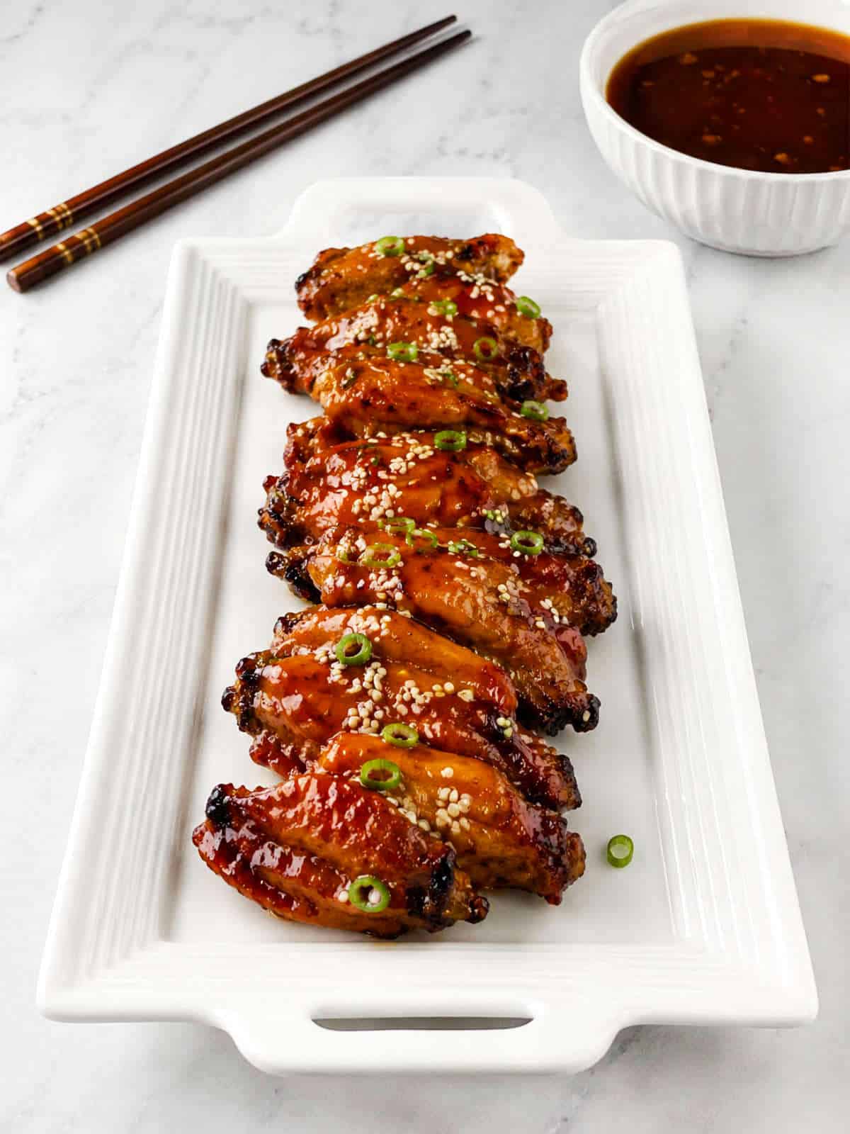 Korean-style soy garlic chicken wings glazed with sesame seeds and sliced green onions.