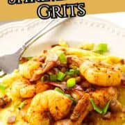 Cajun shrimp on creamy grits with green onions and spices, a fork on the plate, sliced radishes in the background. Text: “Cajun Shrimp and Grits.”.