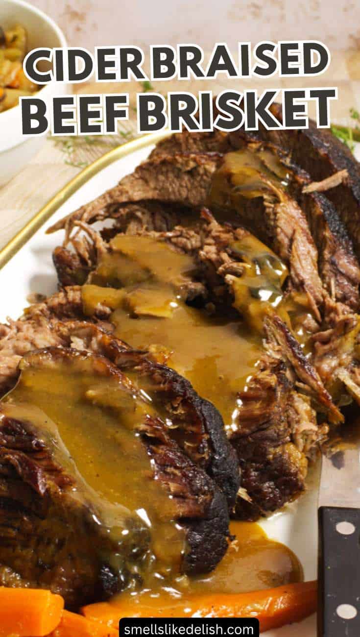 Sliced beef brisket with cider-braised gravy on a white platter, served with carrots and a carving knife; overlaid text reads "CIDER BRAISED BEEF BRISKET.