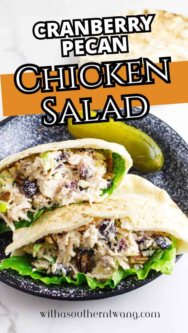Two pita pockets with cranberry pecan chicken salad, lettuce, and a pickle slice on a speckled plate. Text reads "Cranberry Pecan Chicken Salad" and "withasoutherntwang.com.