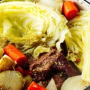 Green Dutch oven holding corned beef, cabbage, carrots, potatoes, onions, and mustard seeds. Text overlay: “Dutch Oven Corned Beef.”.