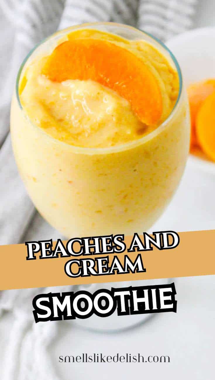A glass of creamy peach smoothie topped with peach slices, with