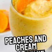 Creamy peach smoothie in a glass with peach slices on a white plate, "Peaches and Cream Smoothie" text overlay, and smellslikedelish.com at the bottom.