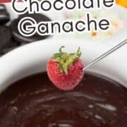 Strawberry on fondue fork dipped in chocolate ganache with “Baileys Chocolate Ganache” text; blurred fruit and cookies in background.