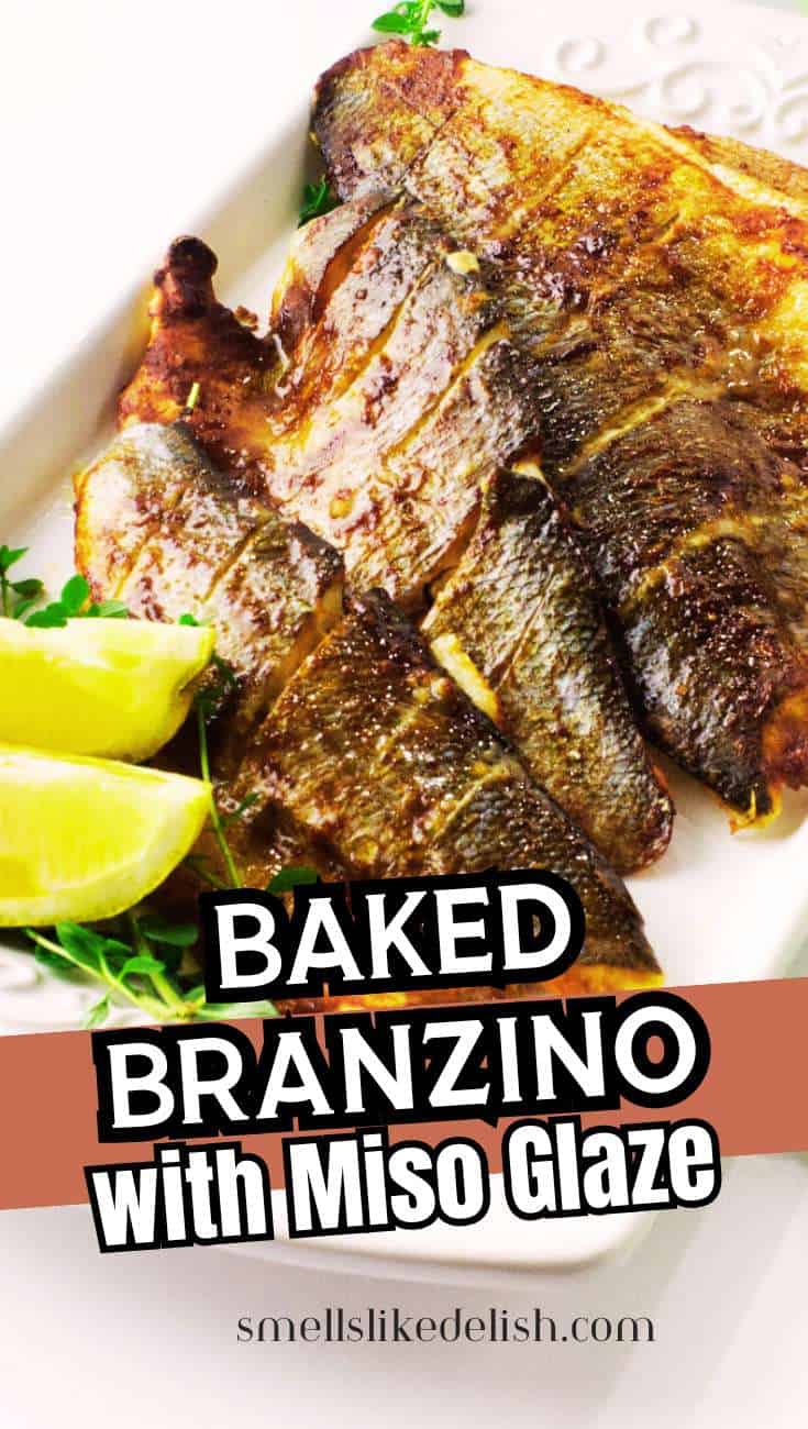 Baked Branzino with golden miso glaze on a white platter, topped with lime wedges and herbs. Text overlay: