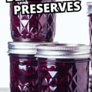 Stacked mason jars of blackberry preserves with the text “Homemade Blackberry Preserves” above and a single blackberry in the lower left.