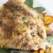 Seasoned turkey breast with herbs and roasted sweet potato wedges on a white plate, featuring the text “Dutch Oven Turkey Breast” and “smellslikedelish.com”.