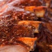 Sliced BBQ pork ribs with crispy crust on a white plate. Top text: “Traeger BBQ Pork Ribs.” Bottom text: “smellslikedelish.com.”.