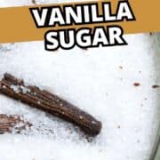 Glass jar containing white sugar and vanilla beans, with “Homemade Vanilla Sugar” text and “smellslikedelish.com” at the bottom.