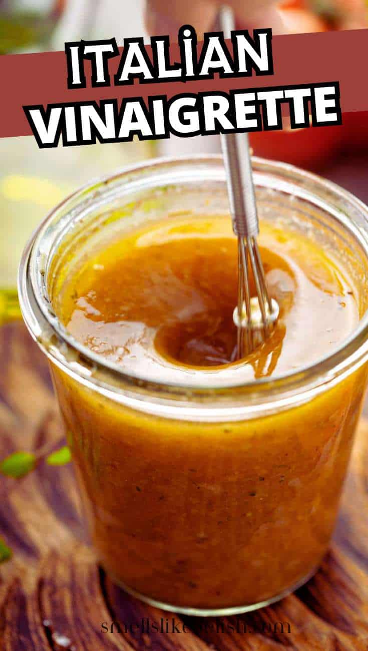 A glass jar of Italian vinaigrette being whisked, with