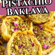 Round pistachio baklava rolls on a plate, garnished with chopped pistachios and rose petals, with text overlay: “1 Hour Pistachio Baklava.”.