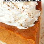 Slice of pumpkin pie with whipped cream and cinnamon on a white plate, text overlay: “Pumpkin Pie Without Evaporated Milk.”.