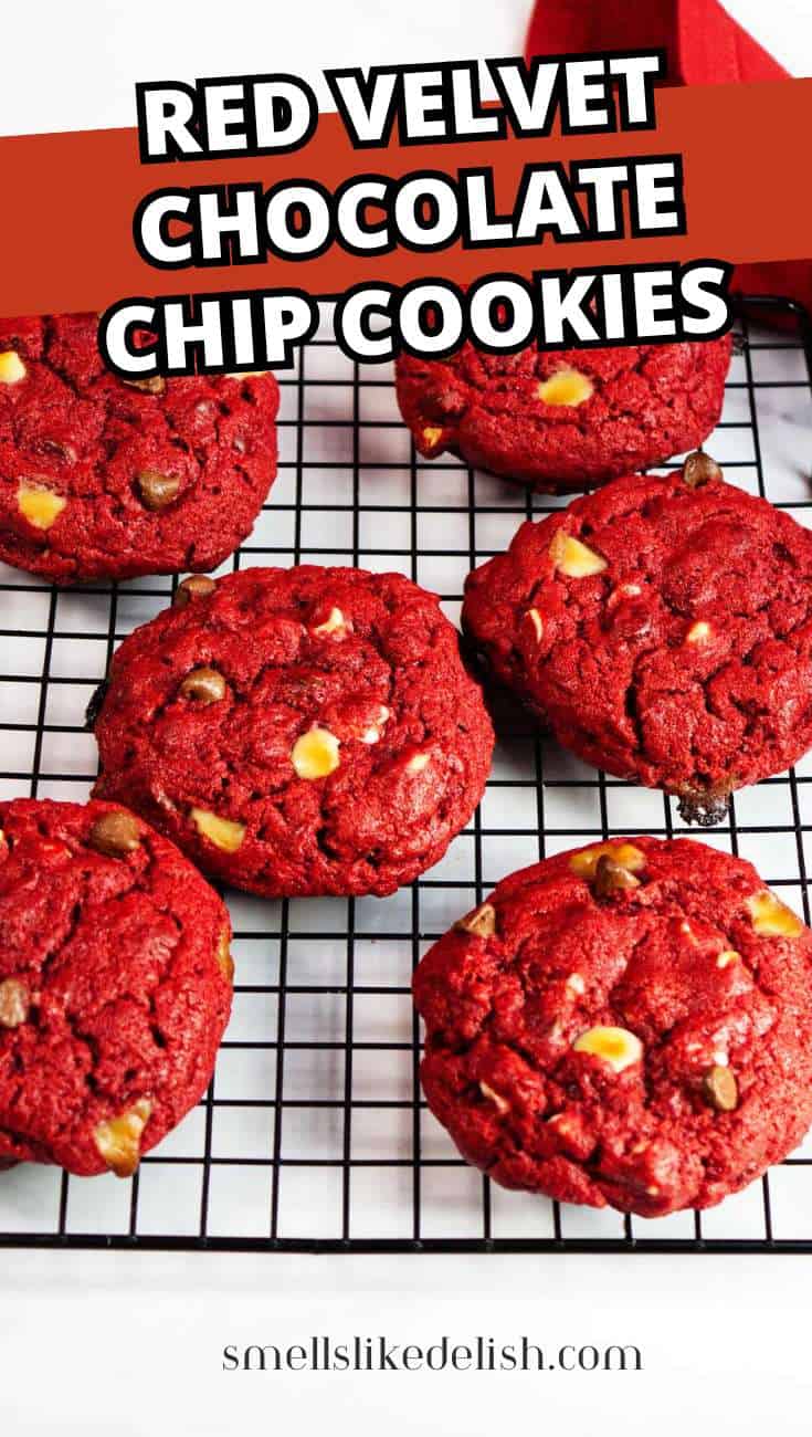 Six red velvet chocolate chip cookies with white and dark chips on a black wire rack,