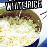 Pot of steamed white rice with serving spoon, labeled “Stovetop Steamed White Rice,” on a white surface next to a folded blue cloth.